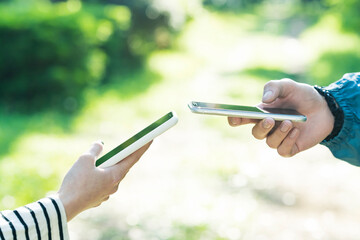 スマートフォンを操作する男女