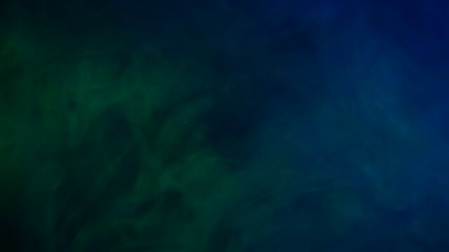 Abstract green and blue smoke in slow motion. Smoke, Cloud of cold fog in light spot background.