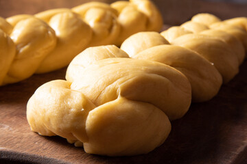 Raw bread dough already in the shape of bread on wood, selective focus.