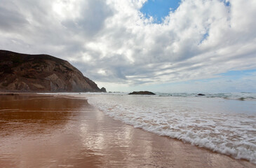 Portugal. The sandy Praia da Castelejo beach in the Algarve on the Atlantic coast. Picturesque seascape. Natural seaside background. Summer travel and recreation