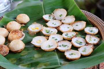 A traditional Thai dessert made from flour mixed with sugar and coconut milk placed on banana leaves.