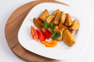 plate of roasted potatoes and fried meatballs on white background