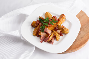 roast pork with potato in a dish with dill and parsley on the table