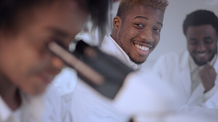 African ethnicity team of scientists having fun during work. Modern laboratory interior