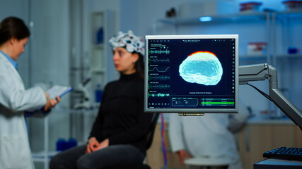Neurologist doctor analysing nervous system using eeg headset scanning woman brain. Scientist...