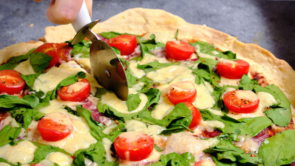 Pizza with cheese, tomatoes, spinach and smoked sausage