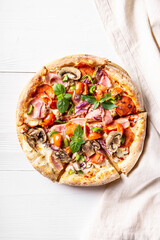 Italian pizza with bacon, pepperoni, mushrooms on white wooden background, vertical orientation, flat lay