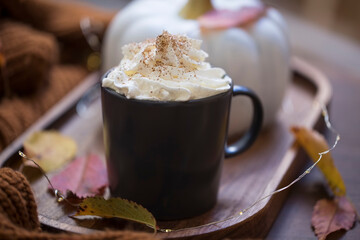 Autumn pumpkin spice latte with whipped cream, seasonal fall pumpkin coffee mug with autumn decor