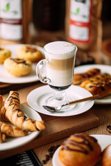 Glass mug of latte macchiato drink with sweet baked food