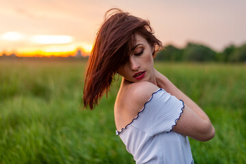 portrait of a beautiful red-haired girl sunset