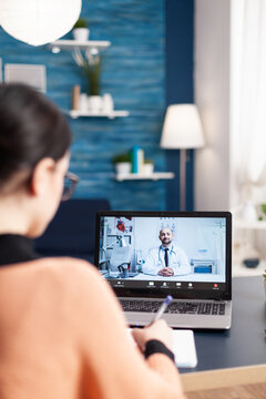 Student Having Online Videcall Conference With Physician Doctor Consulting About Healthcare Treatment. Patient Woman Using Laptop Computer For Medical Consulatation While Sitting In Living Room