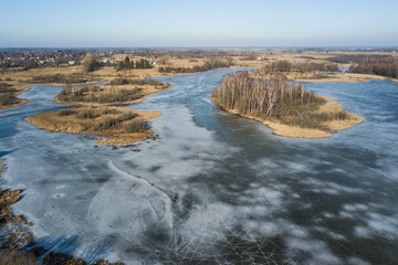 Fototapeta na wymiar Aerial view of frozen water reservoir with islands, Aizpute, Latvia.