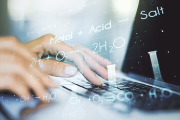 Double exposure of creative chemistry concept with hands typing on laptop on background, research...