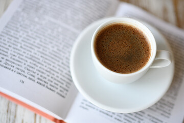 Сup of coffee and a book on table