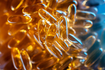close up of food supplement or handful of golden fish oil capsules omega 3