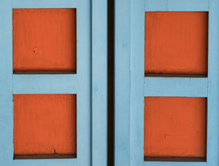 Background image of blue window shutters with decorative squares in orange