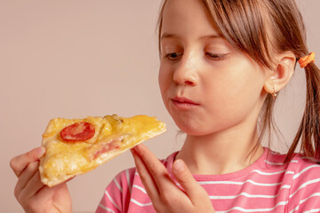 It's really delicious! Young girl is eating a piece of pizza. Selective focus on eyes.