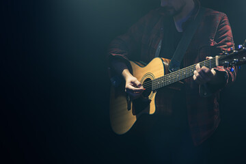 Obraz na płótnie Canvas Acoustic guitar in the hands of a guitarist.