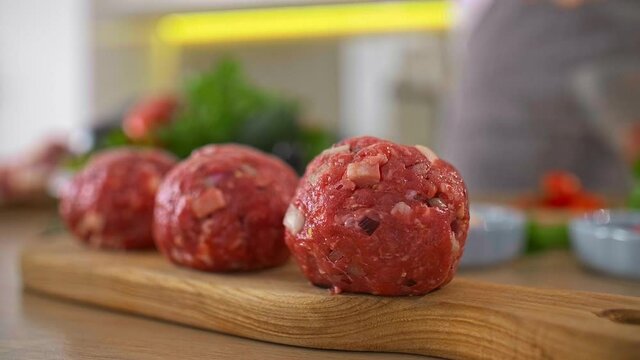 Chef preparing meatballs and putting them on a wooden board