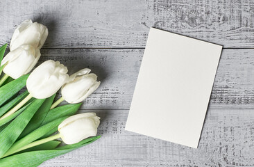 Greeting card with tulip flowers bouquet on wooden background