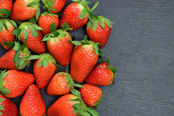 Fresh strawberries close up on slate plate, zenith view. Copy space.