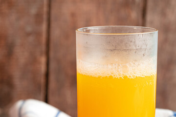 Close up of orange juice glass on wooden table