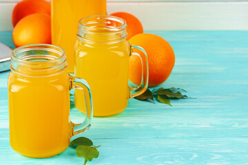 Glass with orange juice on green wooden table