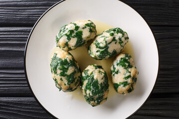 Italian Bread gnocchi with spinach known as Strangolapreti close-up in a plate on the table. Horizontal top view from above