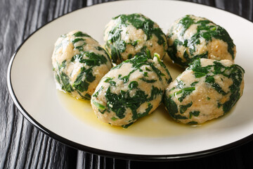 Strangolapreti, Italian Gnocchi Made with Bread and spinach close-up in a plate on the table. Horizontal