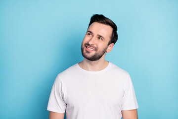 Portrait of attractive minded cheerful guy wearing white tshirt deciding copy space isolated over...