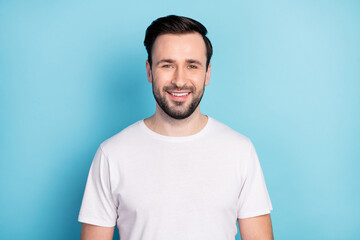 Obraz premium Portrait of attractive cheerful content guy wearing white tshirt isolated over blue bright pastel color background