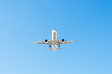 Fototapeta na wymiar Jet plane flying in blue sky, approach for landing.
