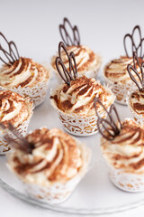 Chocolate muffins with white teapot on a white background