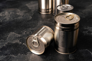 Closed food tin cans on dark background
