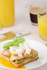 Breakfast with a sandwich with poached egg and avocado