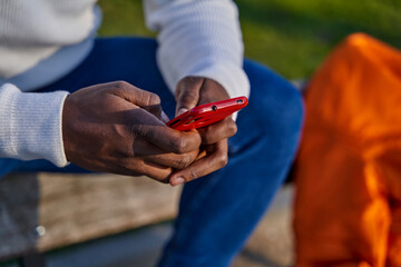 Close-up of black man's hands sending a message with a smart phone. Browsing social networks....
