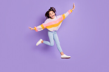 Fototapeta na wymiar Full size photo of young excited girl happy positive smile have fun jump up isolated over purple color background