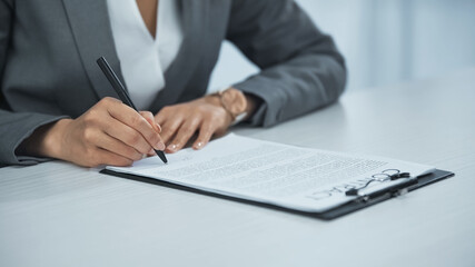 cropped view of businesswoman signing contract