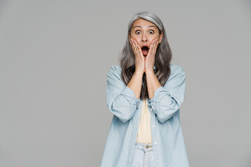 Shocked white-haired woman screaming and expressing surprise at camera