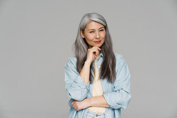 Thinking white-haired woman posing and looking at camera
