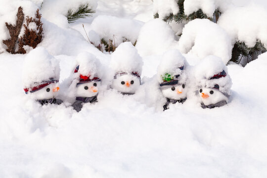 Five snowmen stick in a snow storm