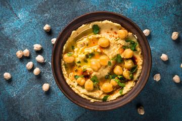 Hummus with olive oil at kitchen table top view.
