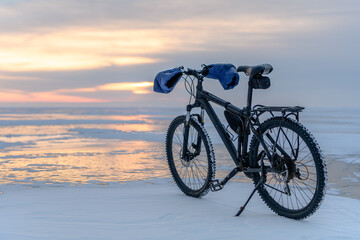 Bycicle on Baikal lake in winter on the sunrise. Irkutsk Region, Russia © evdokimari