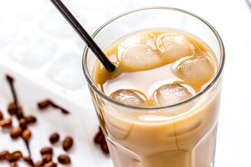 cold coffee glass with ice cubes on white table background