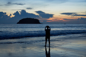 A man using smartphone taking photography at kata beach