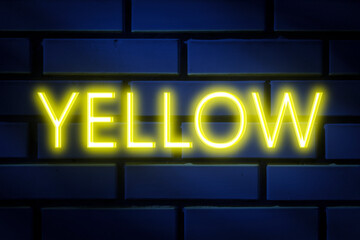 Neon inscription -Yellow on a blue brick wall