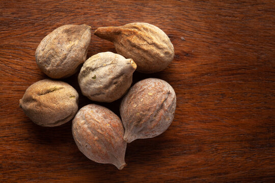 Macro close-up of Organic baheda (Terminalia bellirica) on wooden top background. Pile of Indian Aromatic Spice. Top view