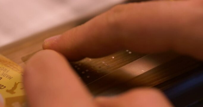 Blind man touches the braille text on a package of spaghetti.