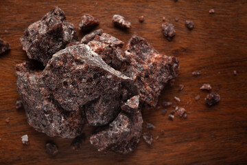 Close-up of coarse Himalayan Black  Salt (sodium chloride) edible on wooden top background.