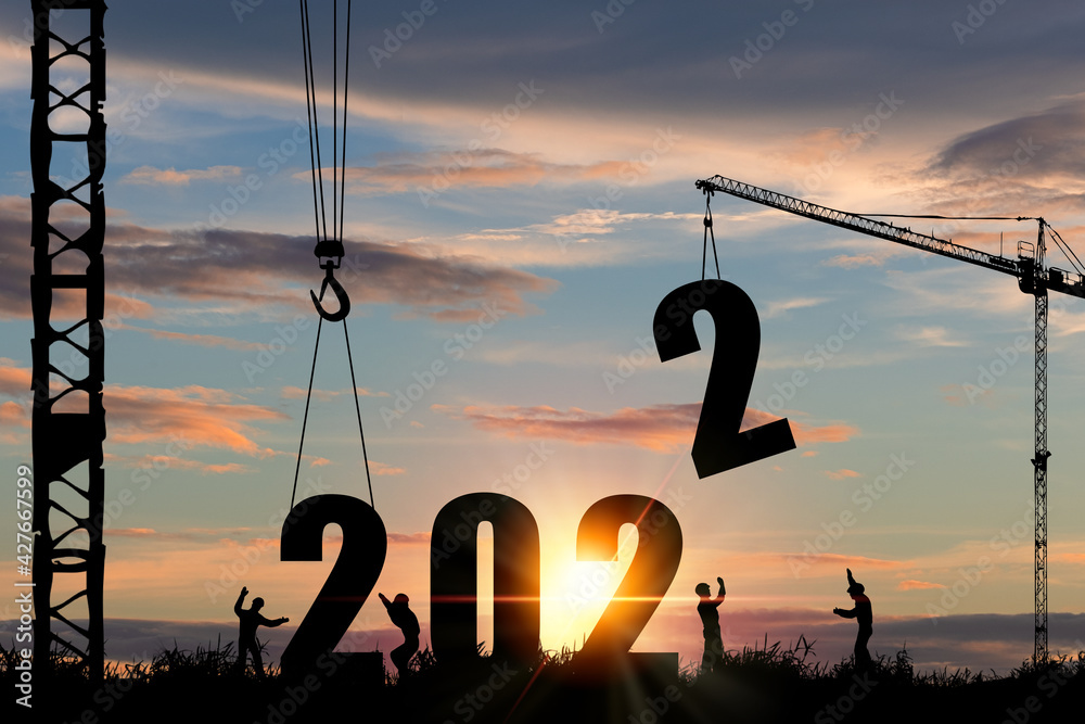 Wall mural silhouette of construction worker with crane and cloudy sky for preparation of welcome 2022 new year